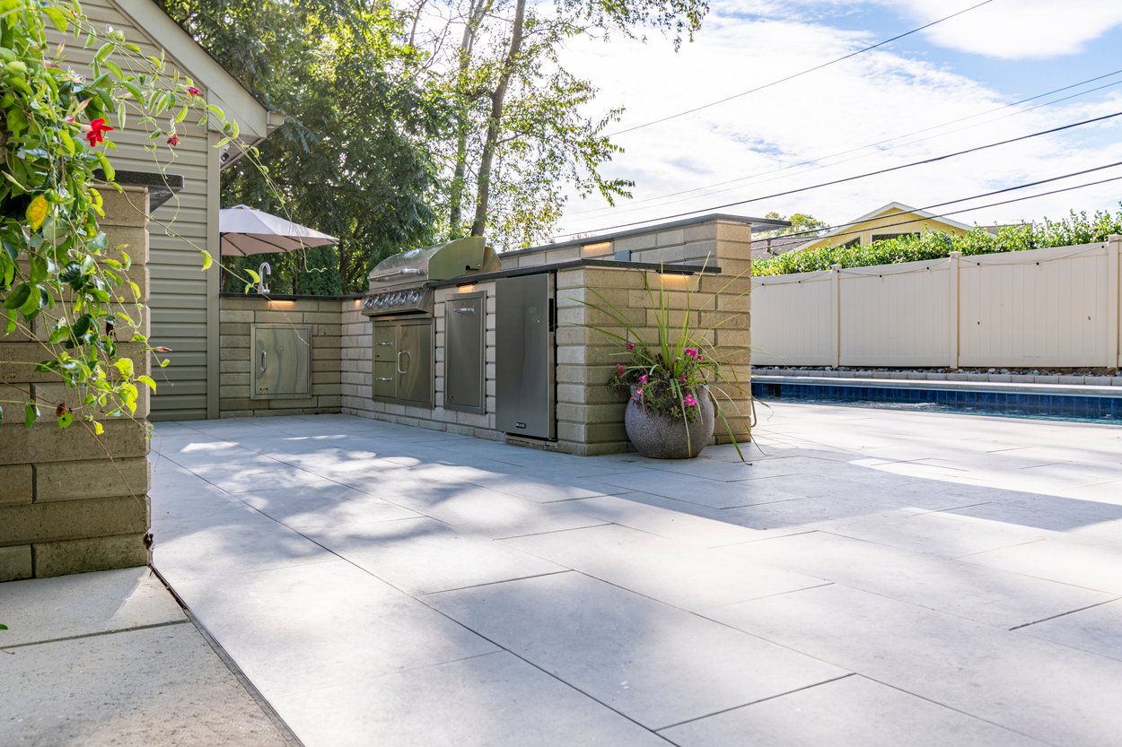 Modern backyard pool and lounge area featuring custom hardscaping in Wilmington, DE