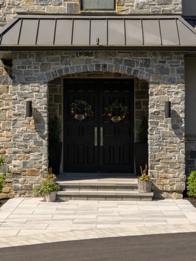 custom home black double front doors framed by stone exterior in wilmington de