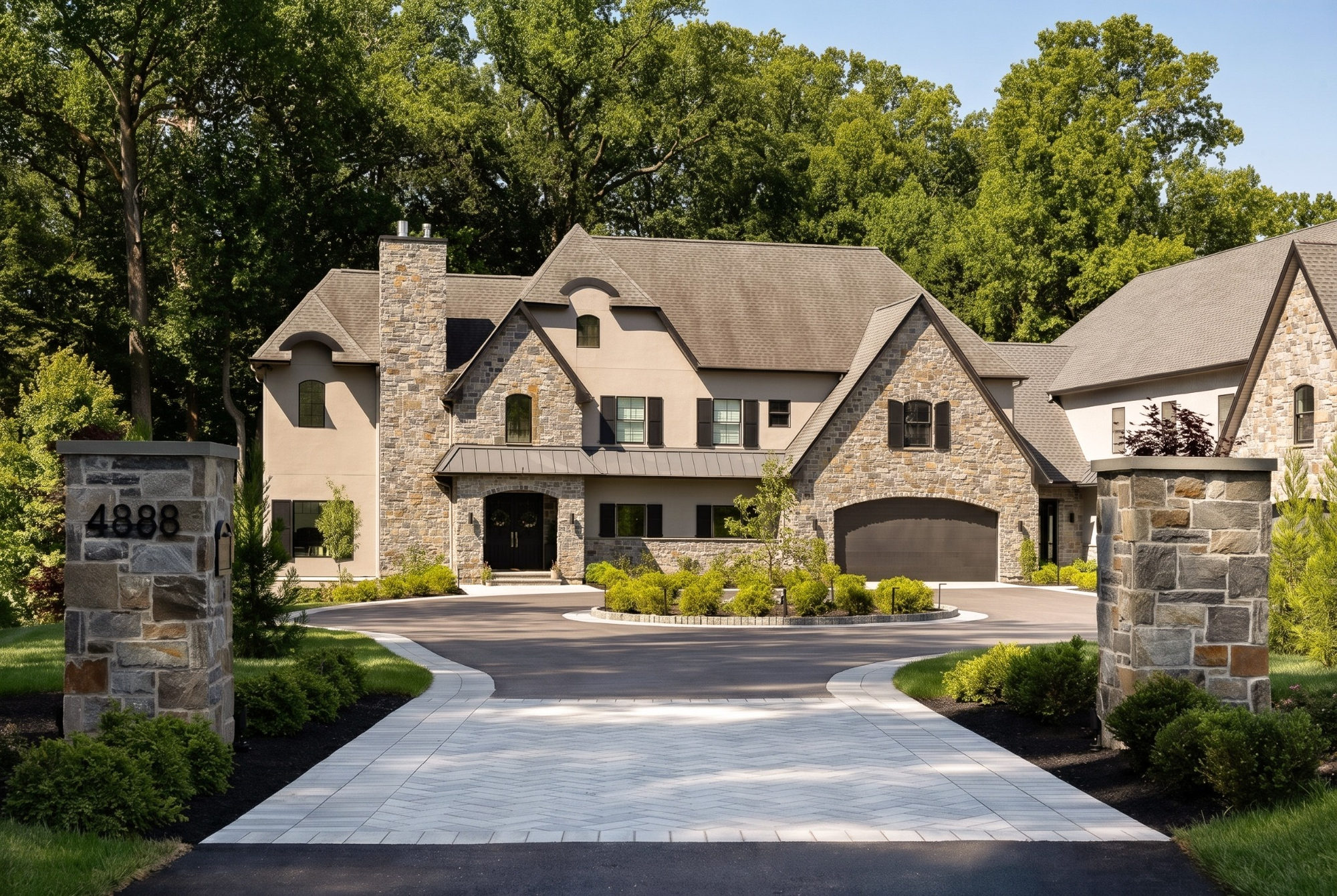 custom home stone exterior with circular driveway and landscaped entrance in wilmington de
