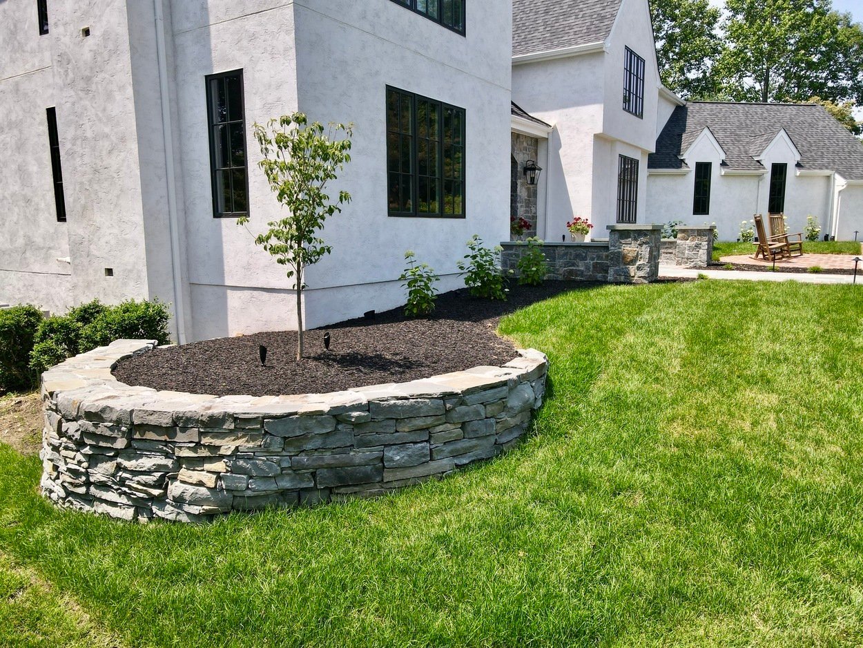 Elevated planter bed built with stacked stone in custom hardscaping and landscaping in Wilmington, DE