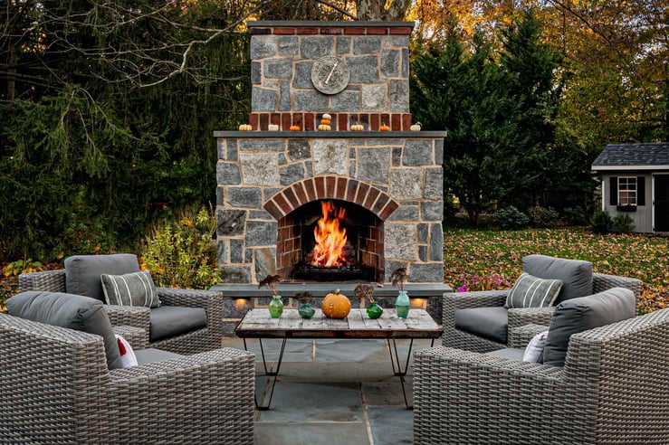 Outdoor Patio With Seating and Custom Stone Fireplace by First Class Lawncare, LLC
