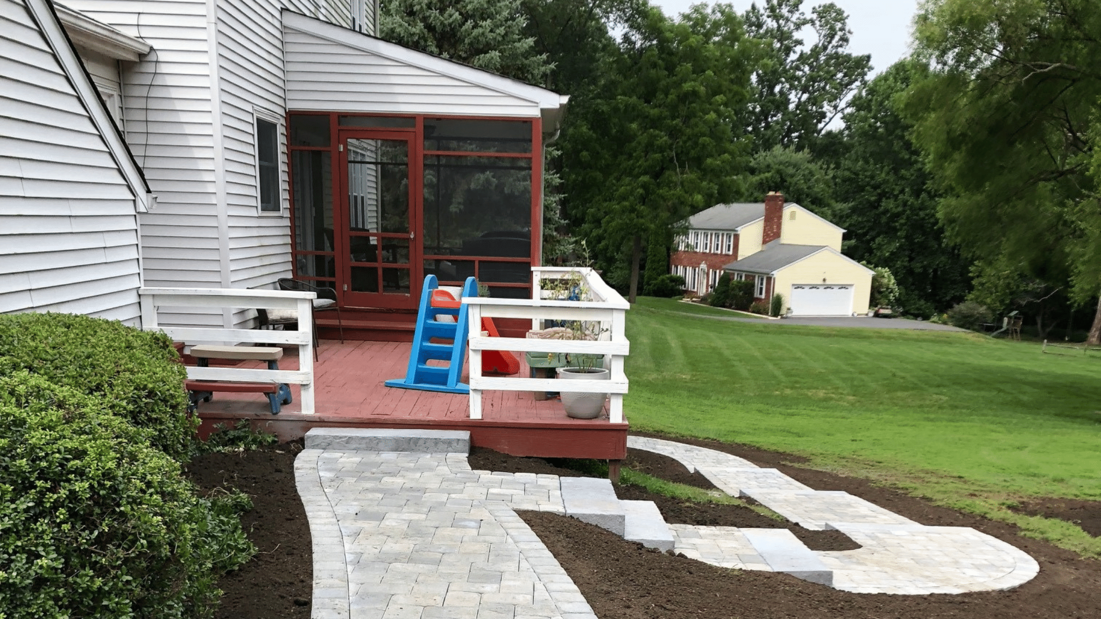 backyard screened porch with fresh dark brown mulch and pathway by first class lawn care in delaware