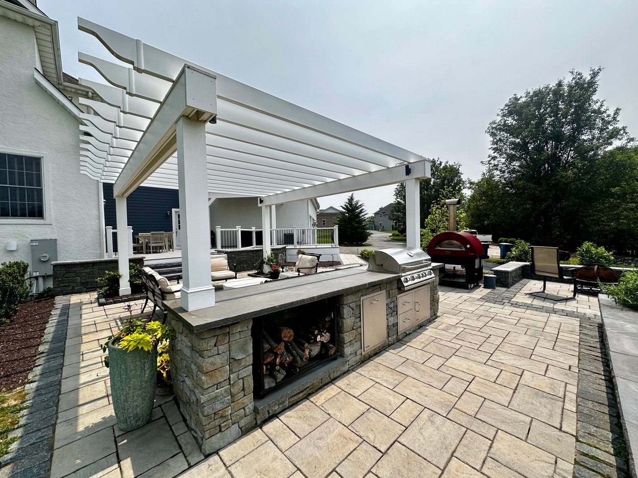 Buit-in outdoor kitchen and patio space featuring pizza oven and grill in Newark, DE outdoor living project