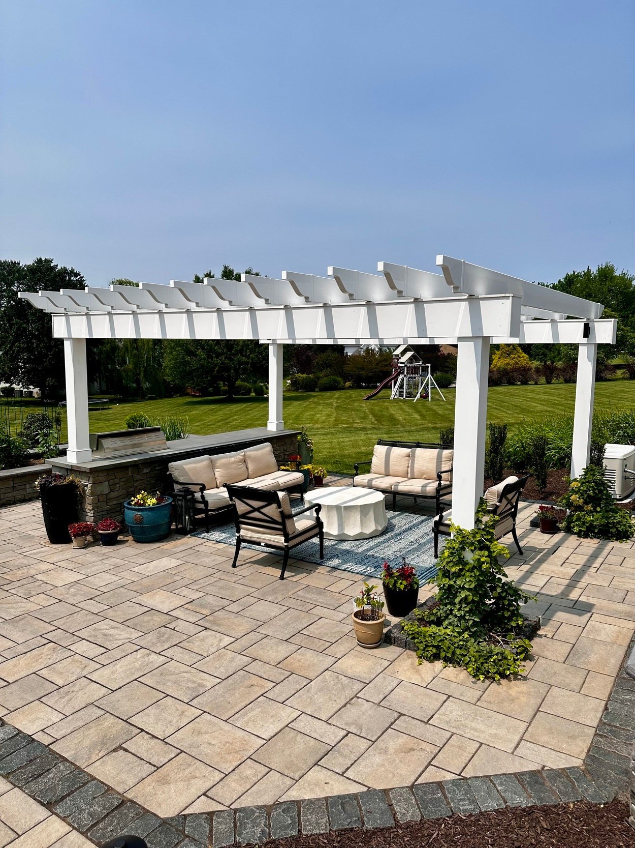 Custom hardscape with pergola, seating, and planters in an outdoor living project in Newark, DE