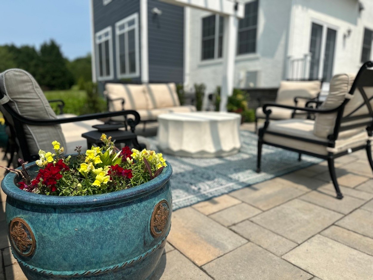 Decorative flower planter in foreground of patio seating in an outdoor living project in Newark, DE