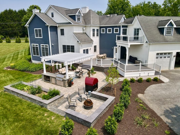Finished outdoor living project in Newark, DE featuring grill island, lounge seating, and fire pit
