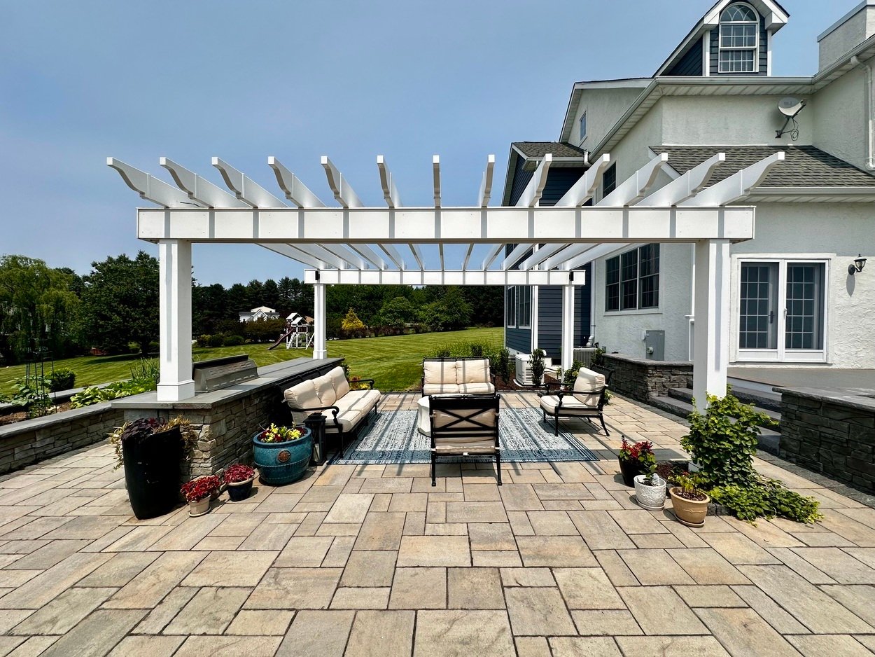 Pergola-covered seating area with outdoor kitchen in an outdoor living project in Newark, DE.
