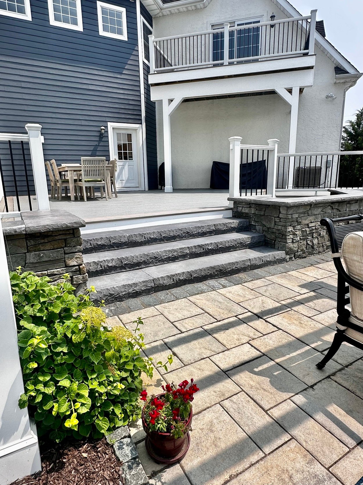Stone steps leading from a composite deck to patio in an outdoor living project in Newark, DE