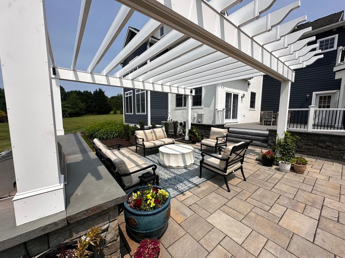 View from pergola corner showing patio furniture and garden beds in outdoor living project in Newark, DE