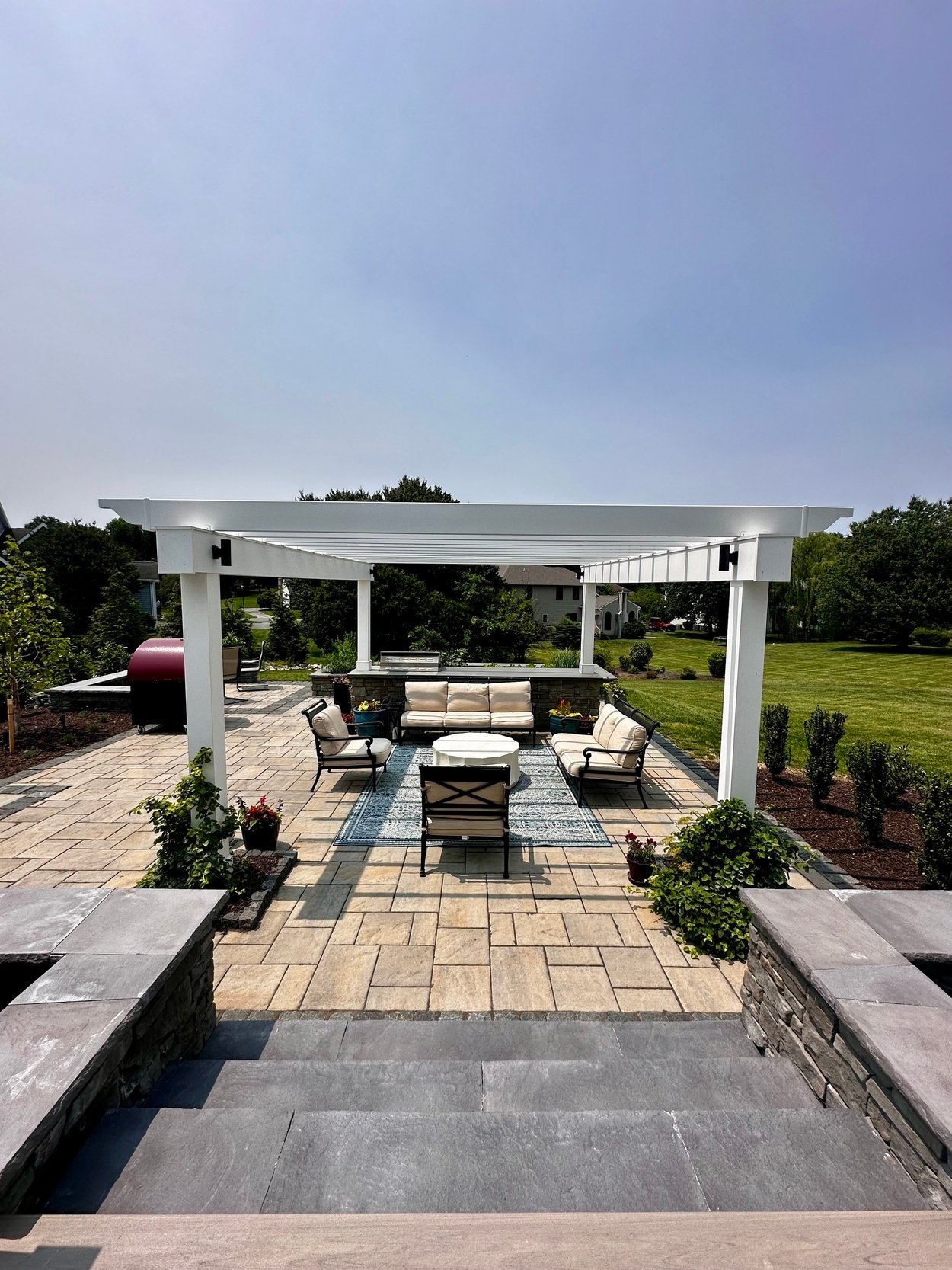 Walk-down entrance to a custom patio with pergola and lounge space in Newark, DE outdoor living project