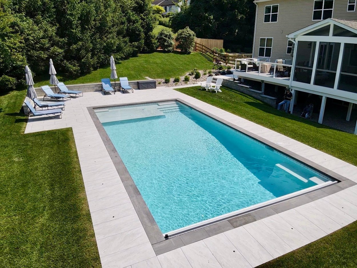 Porcelain patio surrounding a sleek rectangular pool with lounge seating in Newark, DE