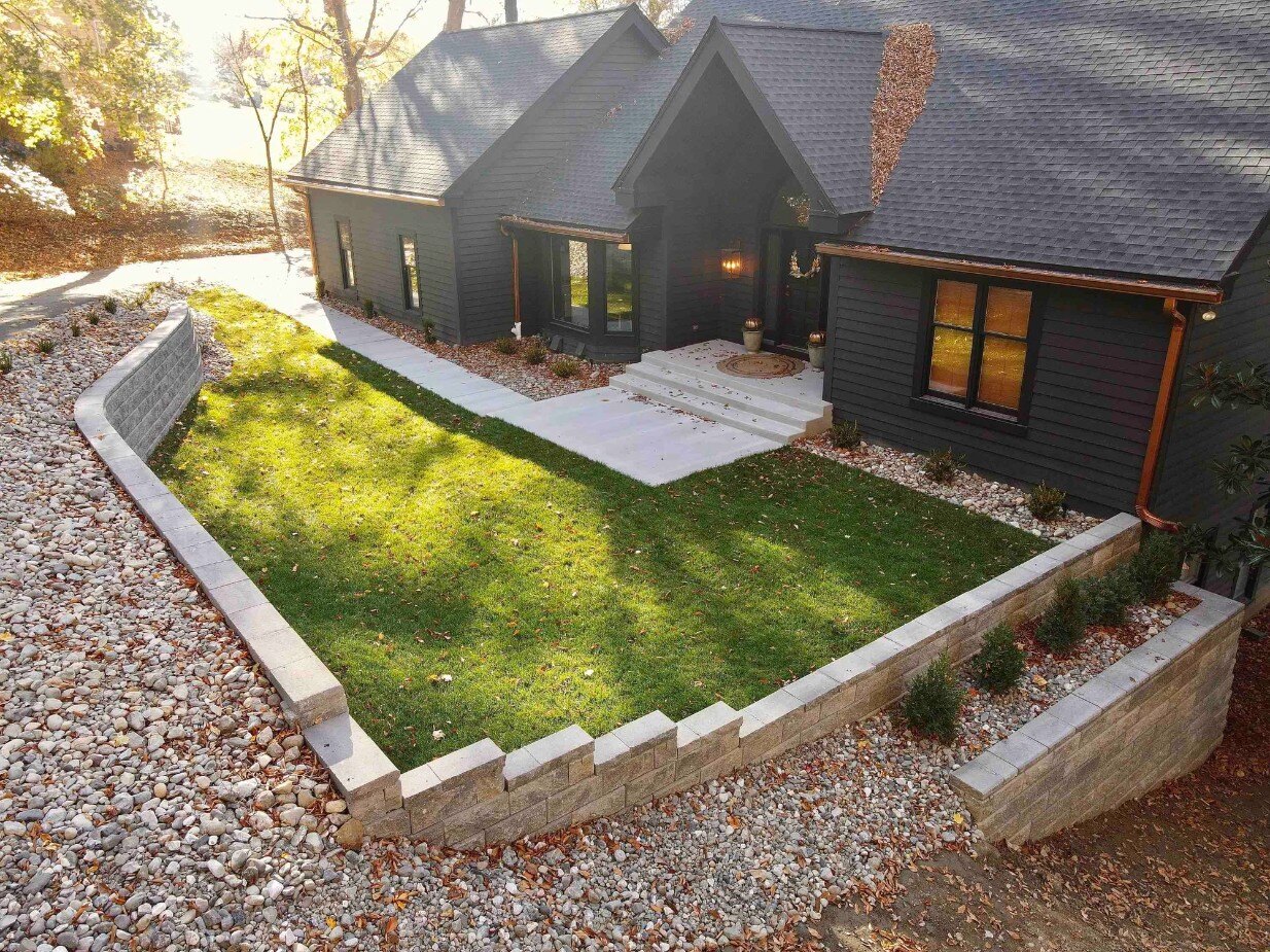 Retaining wall in backyard of dark brown home 