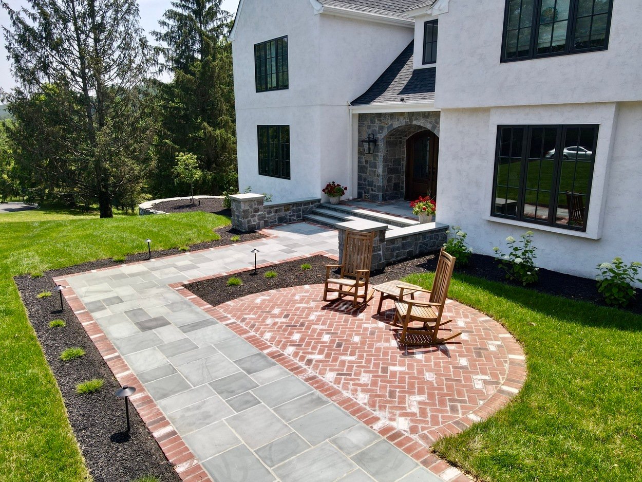 View of front patio seating area with slate walkway in custom hardscaping and landscaping in Wilmington, DE