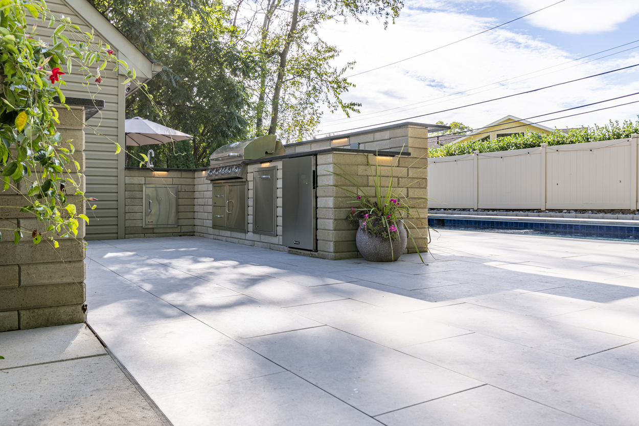 Modern backyard pool and lounge area featuring custom hardscaping in Wilmington, DE
