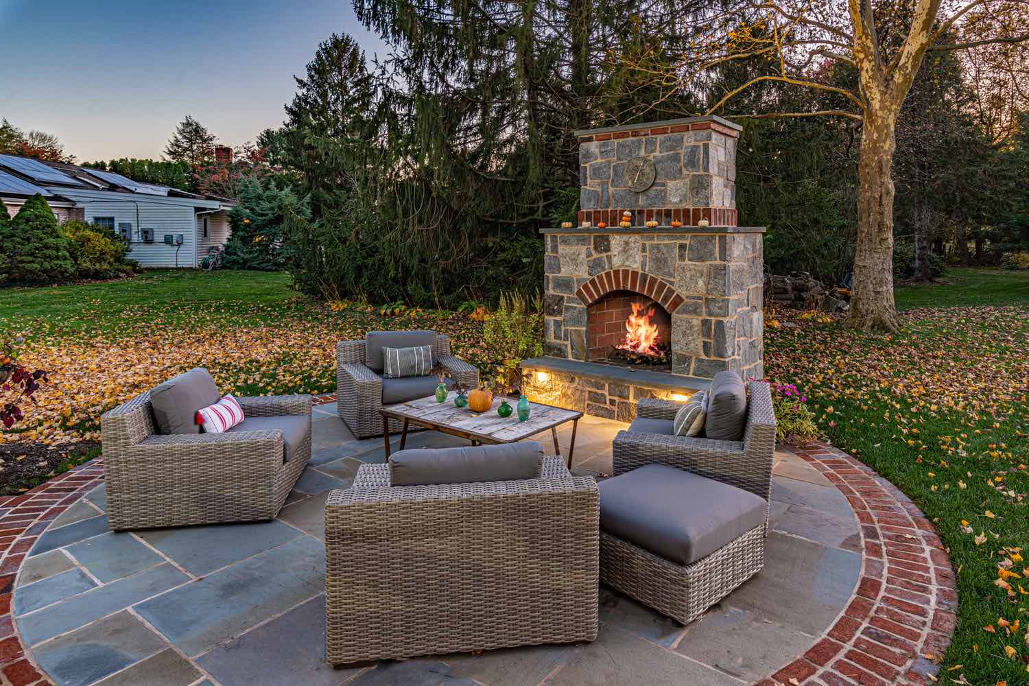 Circular Patio with Stone Fireplace and Seating by First Class Lawn Care