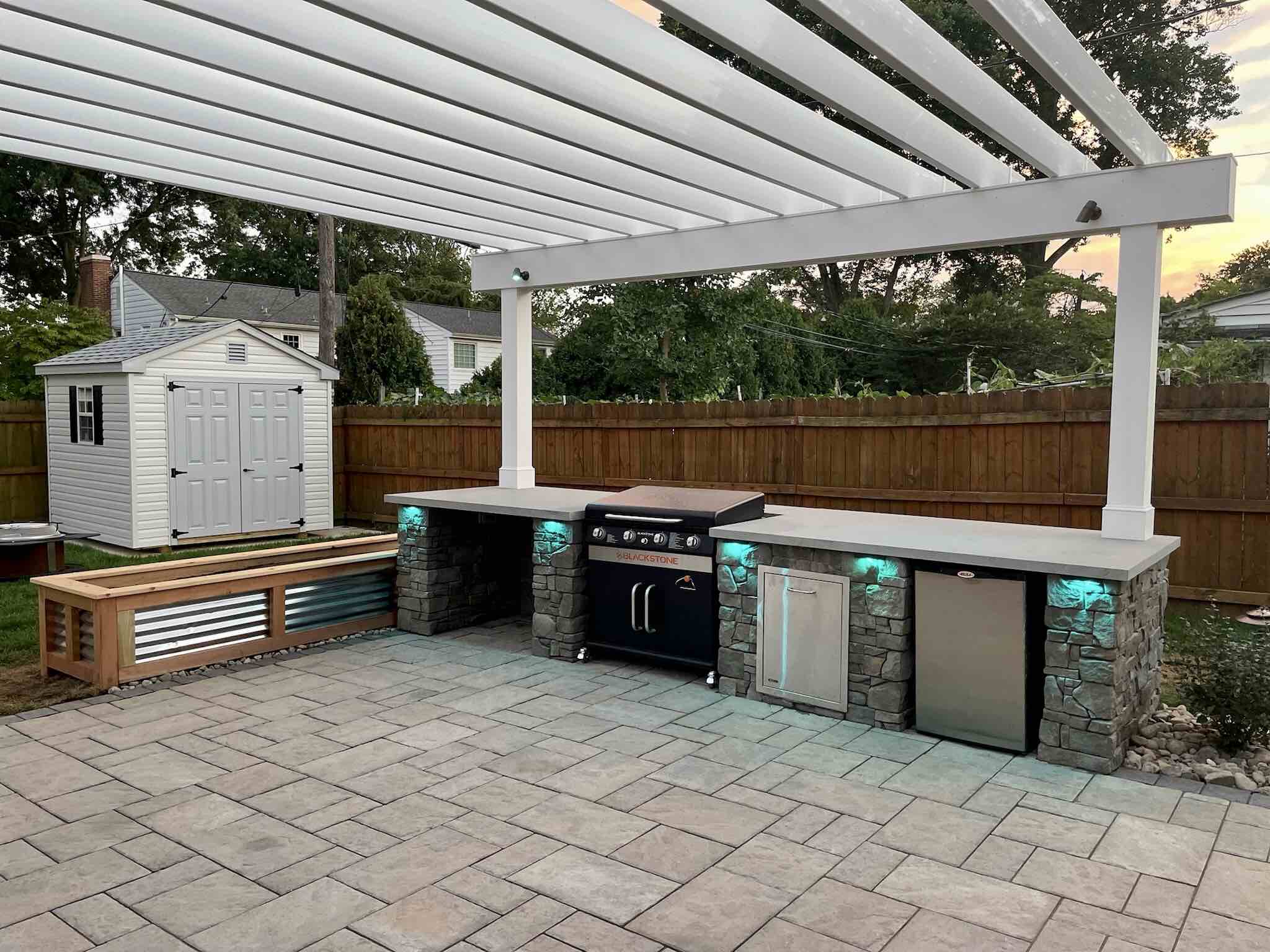 Outdoor Kitchen With Modern Lighting by First Class Lawn Care