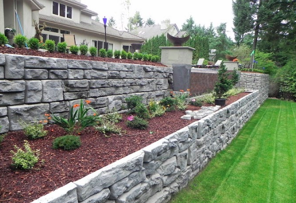 Stone retaining wall with mulch and plants 