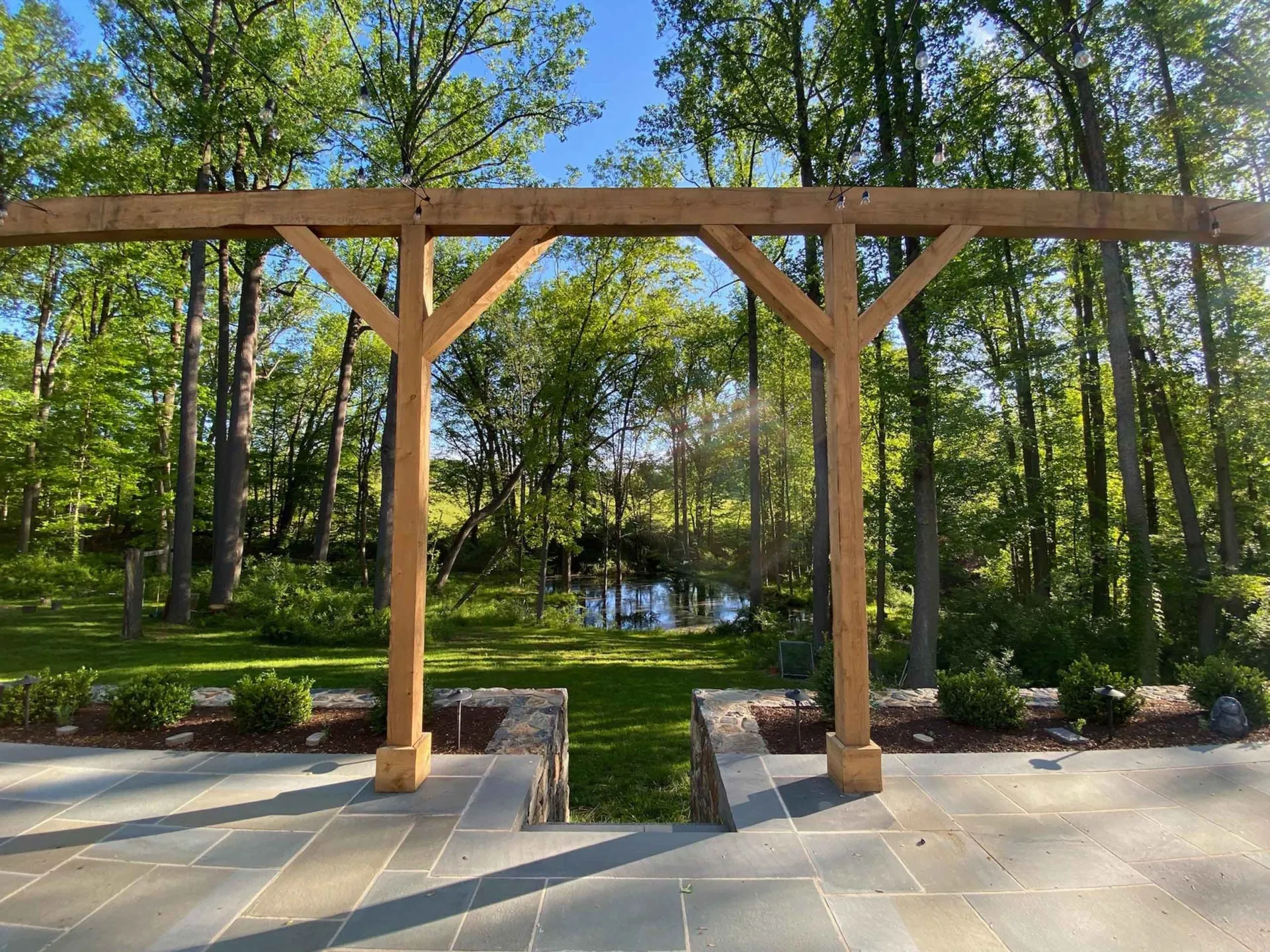 Patio with pergola and hardscaped back yard overlooking water