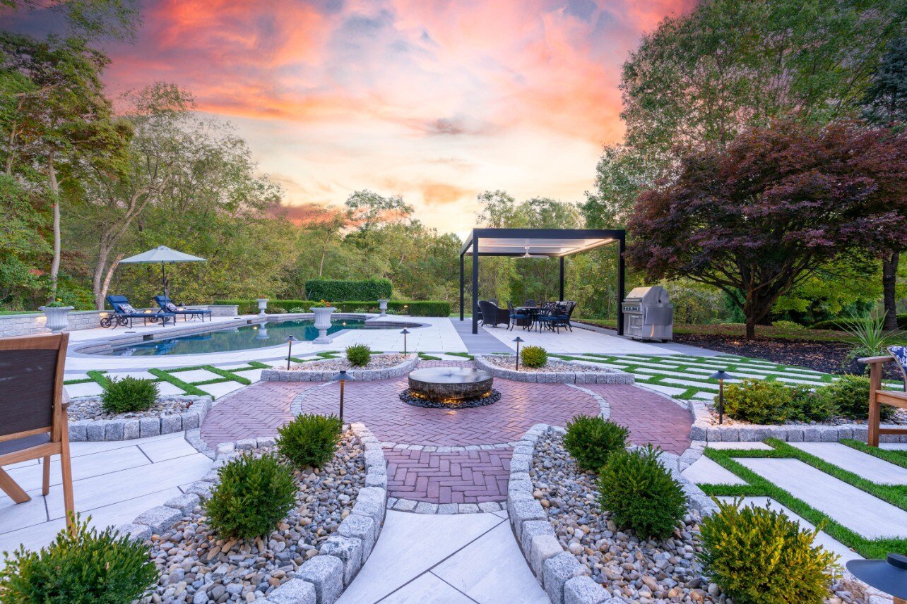 Hardscaped backyard with a central fire pit and pathways, in West Chester, PA by First Class Lawn Care